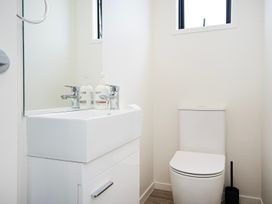 A bathroom with a sink and toilet at Langs Life - Waipu Holiday Home Waipu Cove