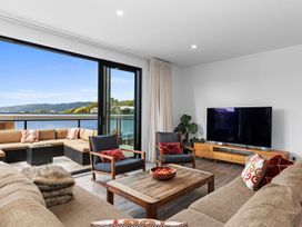 A living room with a sofa and television at Langs Life - Waipu Holiday Home Waipu Cove