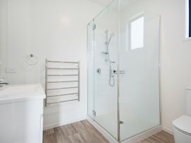 A bathroom featuring a shower, sink, towel rack, and toilet at Langs Life - Waipu Holiday Home, Waipu Cove