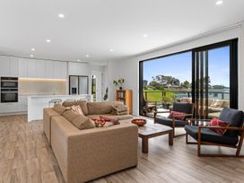 A living room with a sofa and coffee table at Langs Life - Waipu Holiday Home in Waipu Cove
