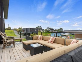 A lounge area with a sectional sofa and coffee table at Langs Life - Waipu Holiday Home Waipu Cove