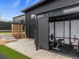 An outdoor gym with a weight bench and barbell at Langs Life - Waipu Holiday Home Waipu Cove