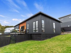An outdoor view of a house with a deck at Langs Life - Waipu Holiday Home, Waipu Cove