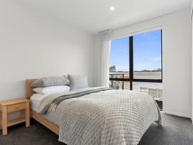 A bedroom with a bed and a window at Langs Life - Waipu Holiday Home Waipu Cove