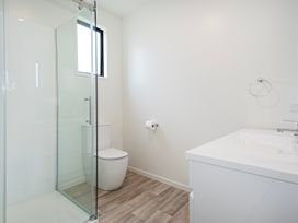 A bathroom with a shower, toilet, and sink at Langs Life - Waipu Holiday Home Waipu Cove