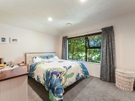 A bedroom with a bed and window at Magnolia Cottage - Nelson Holiday Homes Levin