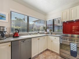 A kitchen with appliances and a view at Magnolia Cottage - Nelson Holiday Homes in Levin