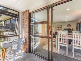 A living room with a dining area and desk at Magnolia Cottage - Levin