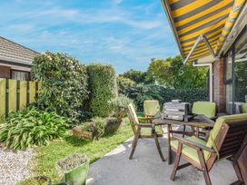 A garden with a table and chairs and a grill at Magnolia Cottage - Levin