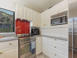 A kitchen with appliances and cabinetry at Magnolia Cottage - Levin