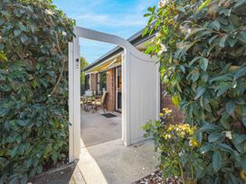 An outdoor patio area with seating and a gate at Magnolia Cottage - Nelson Holiday Homes in Levin