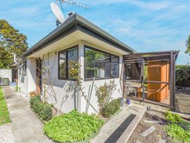 An outdoor view of a house with a garden area at Magnolia Cottage - Nelson Holiday Homes Levin