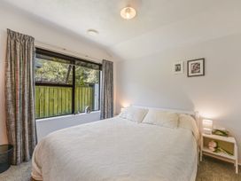 A bedroom with a bed and window at Magnolia Cottage - Nelson Holiday Homes in Levin