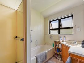 A bathroom featuring a bathtub, shower, and sink at Magnolia Cottage - Nelson Holiday Homes