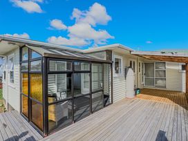 A veranda with a glass enclosure and wooden deck at Home away from Home - Levin Holiday Home, Foxton