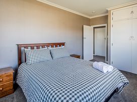 A bedroom with a bed and nightstand at Home away from Home - Levin Holiday Home in Foxton
