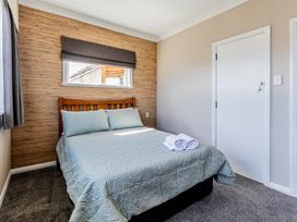 A bedroom with a bed and towels at Home away from Home - Levin Holiday Home Foxton