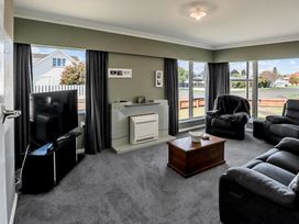 A living room with a television and seating at Home away from Home - Levin Holiday Home in Foxton