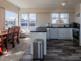 A kitchen with a dining table and appliances at Home away from Home - Levin Holiday Home in Foxton