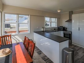 A kitchen with a dining table and appliances at Home away from Home - Levin Holiday Home in Foxton
