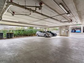 A parking lot with cars and garbage bins at Westlight Apartment - Henderson Holiday Home Auckland