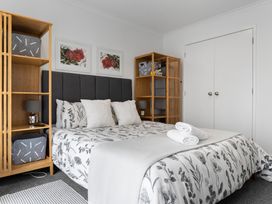 A bedroom with a bed and shelves at Westlight Apartment - Henderson Holiday Home in Auckland