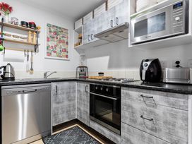 A kitchen with appliances and utensils at Westlight Apartment - Henderson Holiday Home, Auckland