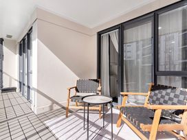 A balcony with two chairs and a round table at Westlight Apartment - Henderson Holiday Home, Auckland