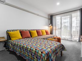 A living room with a sofa and cushions at Westlight Apartment - Henderson Holiday Home, Auckland