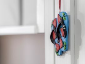 A decorative flip flop hanging on a wall at Westlight Apartment - Henderson Holiday Home, Auckland
