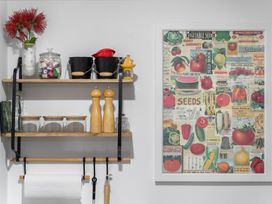 A kitchen shelf with jars and utensils at Westlight Apartment - Henderson Holiday Home, Auckland