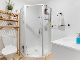 A bathroom with a shower and toilet at Westlight Apartment - Henderson Holiday Home, Auckland