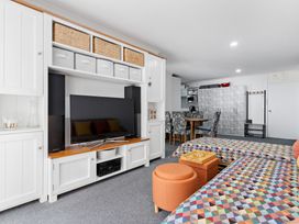 A studio with beds, a TV unit, and a dining area at Westlight Apartment - Henderson Holiday Home, Auckland