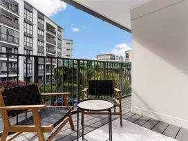 A balcony with chairs and a table at Westlight Apartment - Henderson Holiday Home, Auckland