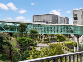 An outdoor area with a pedestrian bridge connecting buildings at Westlight Apartment - Henderson Holiday Home, Auckland