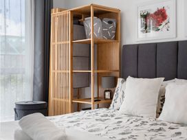 A bedroom with a bed and storage unit at Westlight Apartment - Henderson Holiday Home Auckland