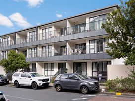 An apartment building with balconies in front of parked cars at Westlight Apartment - Henderson Holiday Home, Auckland