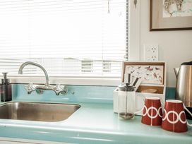 A kitchen sink with faucet and mugs at Southern Base - Te Anau Holiday Home in Te Anau