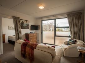 A living room with a sofa and television at Southern Base - Te Anau Holiday Home in Te Anau