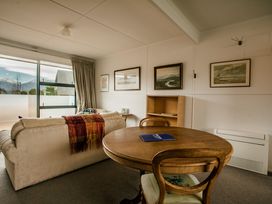 A living room with a sofa, table, and pictures at Southern Base - Te Anau Holiday Home in Te Anau