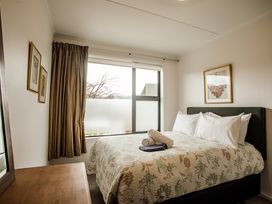 A bedroom with a bed and window at Southern Base - Te Anau Holiday Home in Te Anau