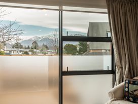 A living room view of mountains and houses at Southern Base - Te Anau Holiday Home Te Anau