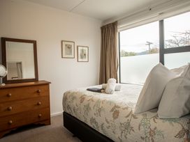 A bedroom with a bed and dresser at Southern Base - Te Anau Holiday Home in Te Anau