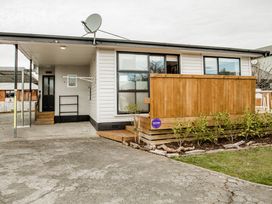 A house with a wooden deck and satellite dish at Southern Base - Te Anau Holiday Home in Te Anau