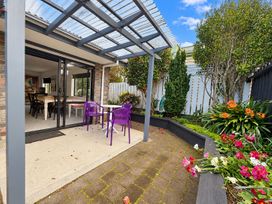 An outdoor patio with purple chairs and a table at Gallery Grove - New Plymouth Holiday Home, New Plymouth