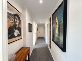 A hallway with artwork and a console table at Gallery Grove - New Plymouth Holiday Home, New Plymouth