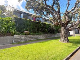 A house with a hedge and tree at Gallery Grove - New Plymouth Holiday Home New Plymouth