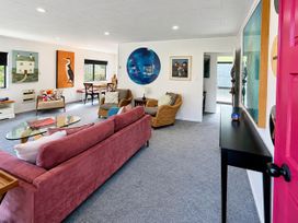A living room with a sofa, coffee table, and artwork at Gallery Grove - New Plymouth Holiday Home New Plymouth