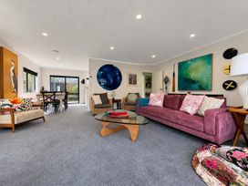 A living room with a purple sofa and coffee table at Gallery Grove - New Plymouth Holiday Home, New Plymouth