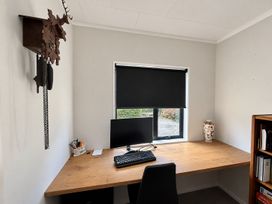 An office with a desk and computer monitor at Gallery Grove - New Plymouth Holiday Home New Plymouth
